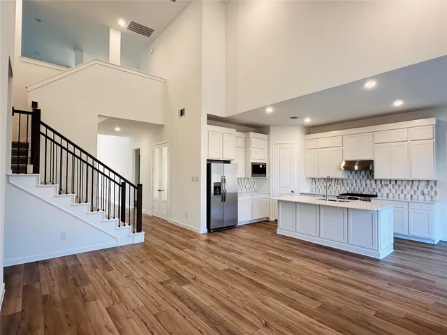 a kitchen with stainless steel appliances a refrigerator and a stove top oven