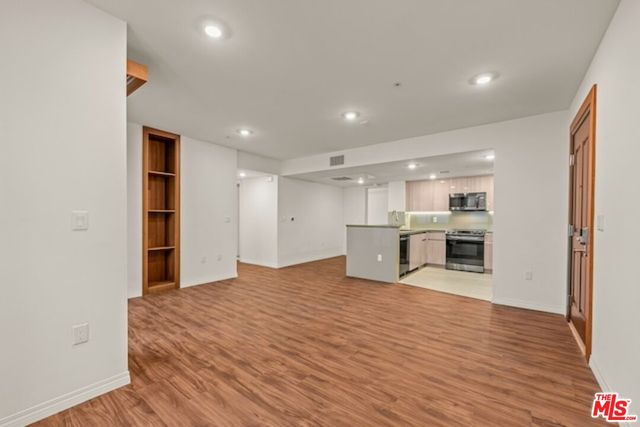 a view of a kitchen with kitchen island refrigerator sink microwave and cabinets