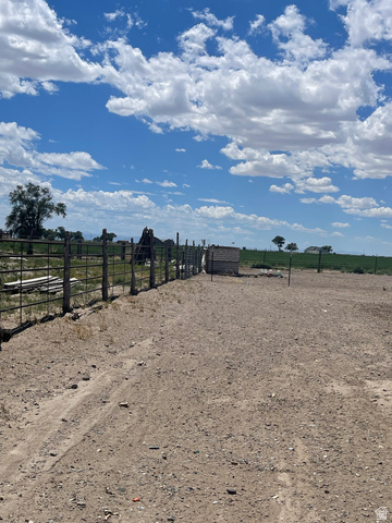 289 West Center Street Hinckley, UT 84635 - Photo 12 of 13 Expansive land parcel featuring a metal fence line, a small block structure, and a broad dirt surface