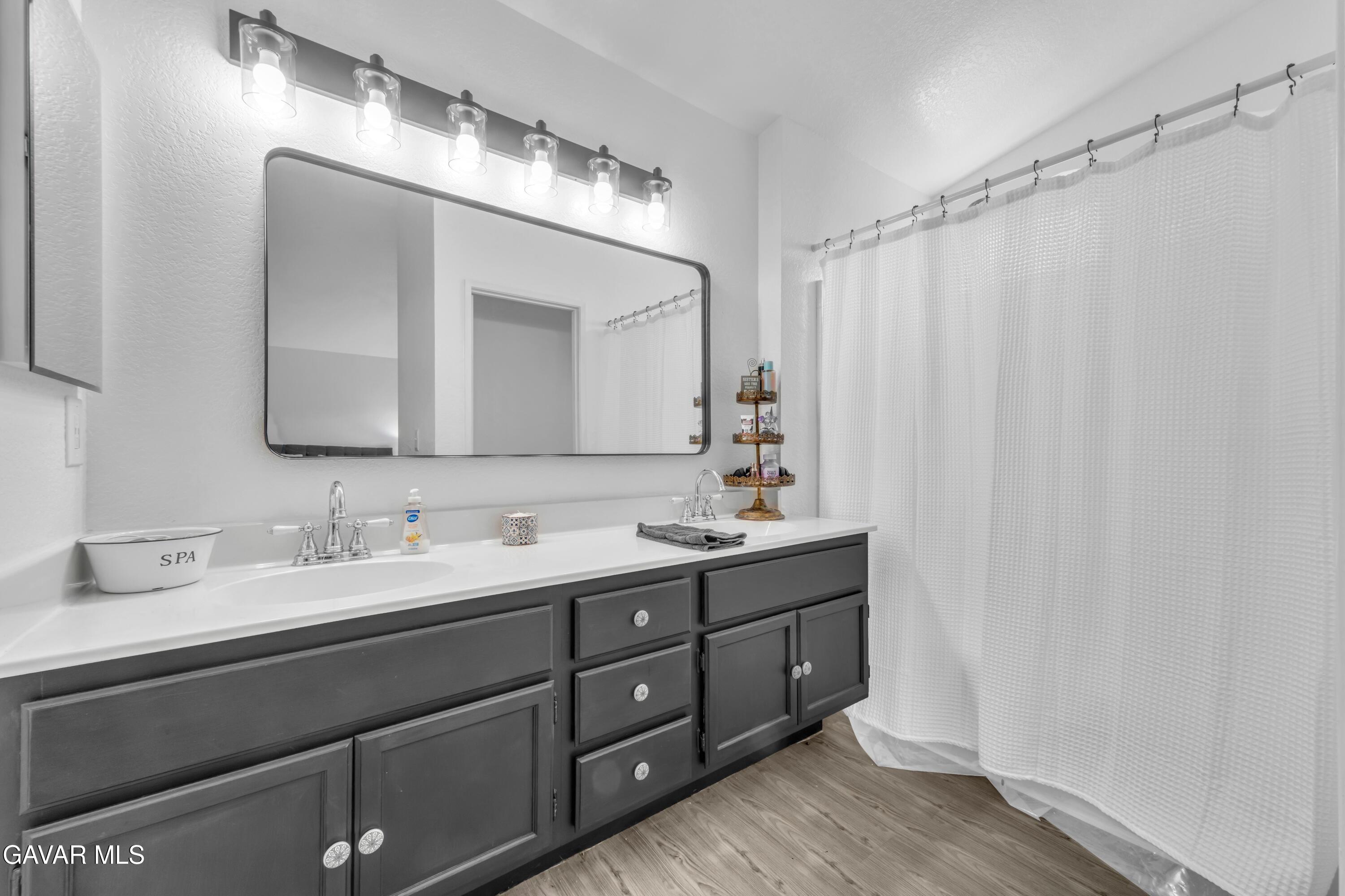 3046 Hampton Road Palmdale, CA 93551 - Photo 19 of 27 a bathroom with a double vanity sink and a mirror