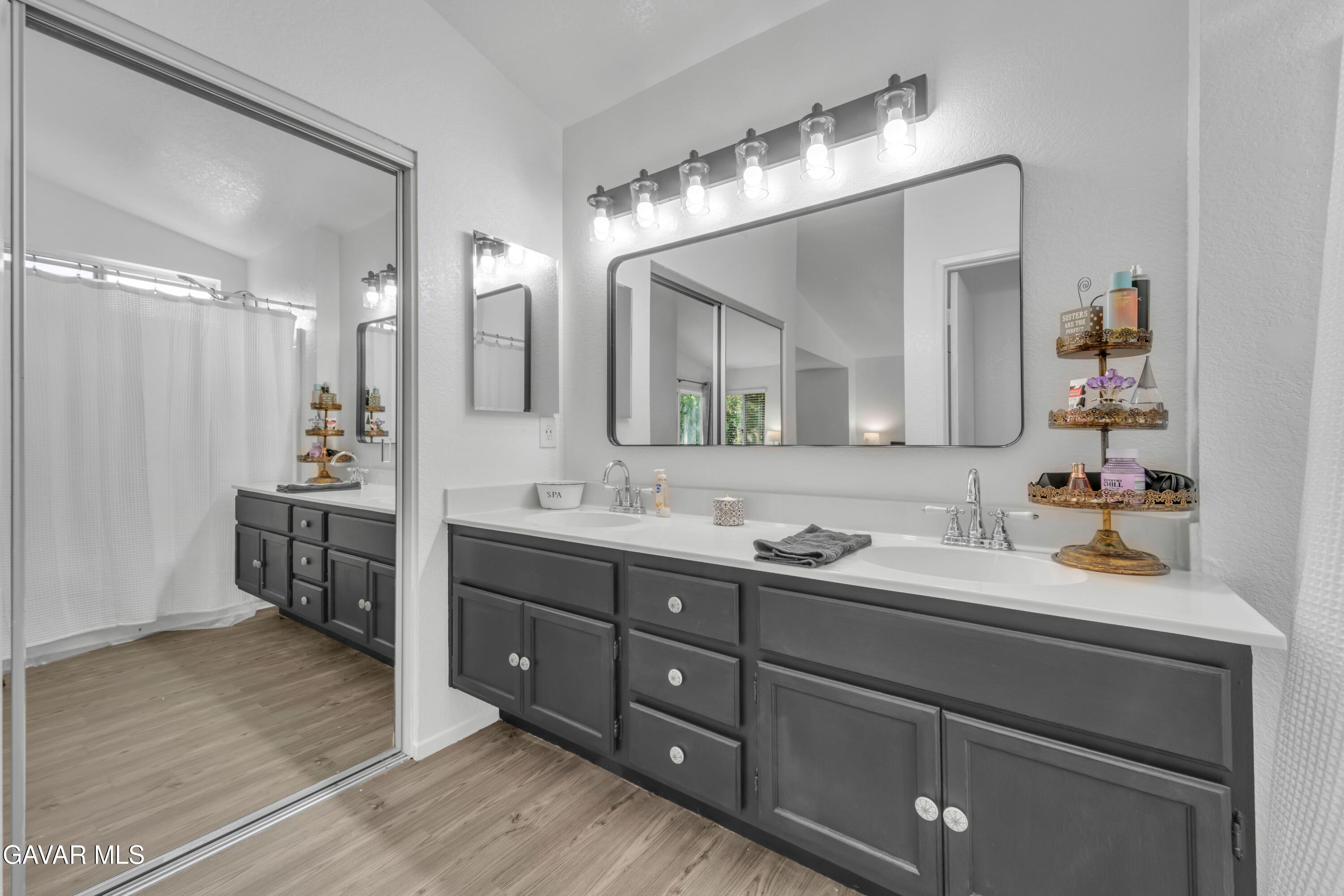 3046 Hampton Road Palmdale, CA 93551 - Photo 20 of 27 a bathroom with a double vanity sink and a mirror