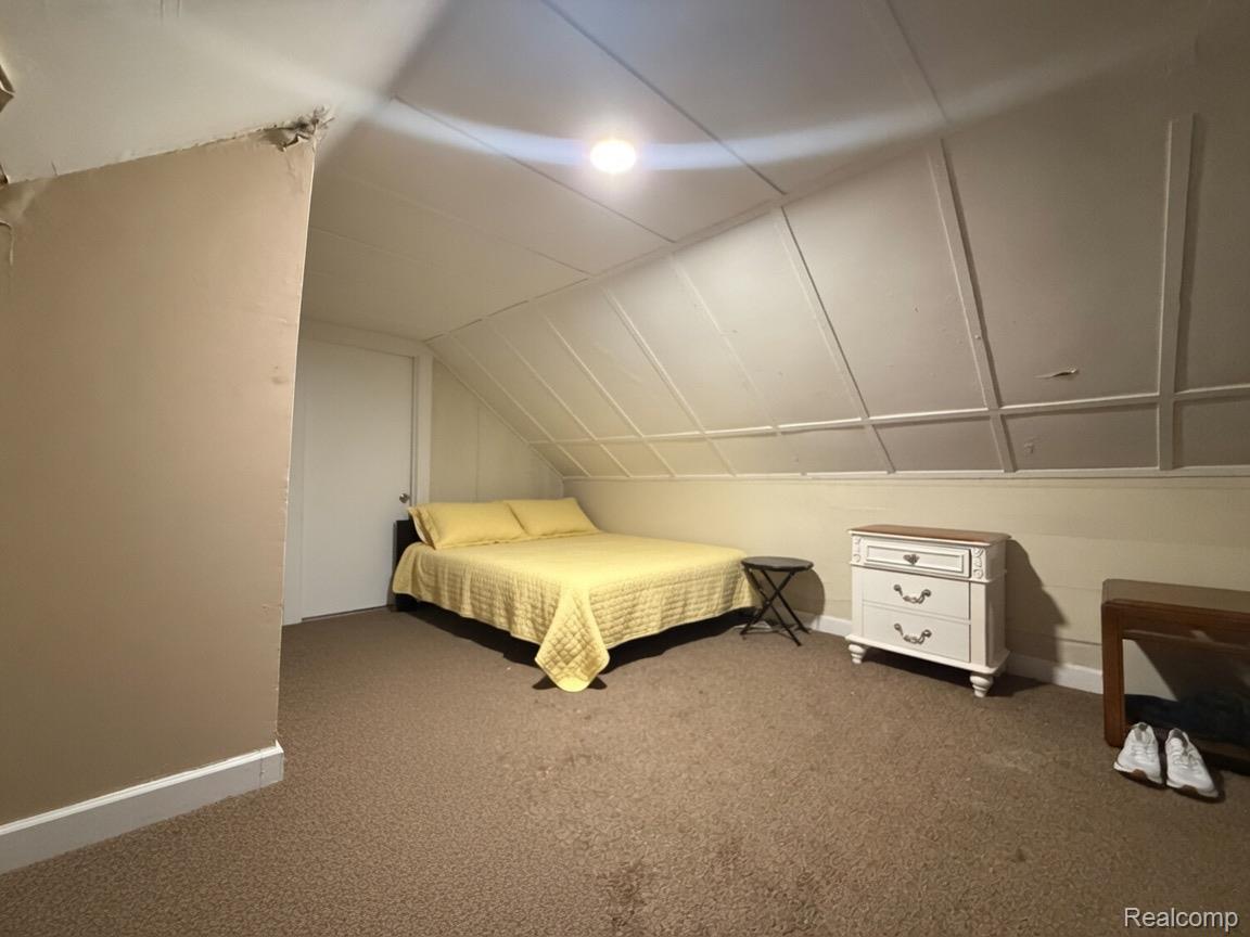 9940 Manor Detroit, MI 48204 - Photo 14 of 16 Carpeted room featuring a sloped ceiling with decorative paneling and a flush-mount ceiling light