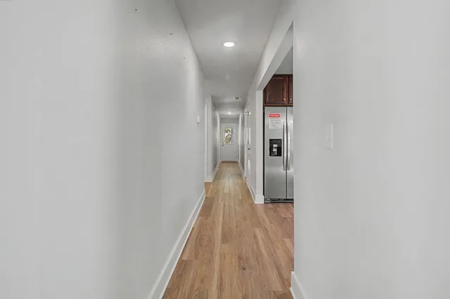 a view of hallway with wooden floor