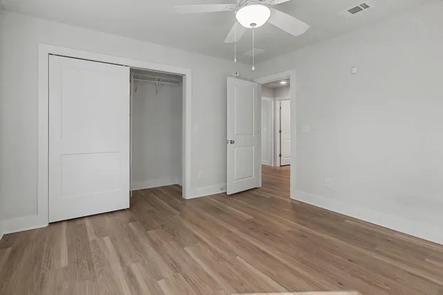 a view of an empty room with wooden floor
