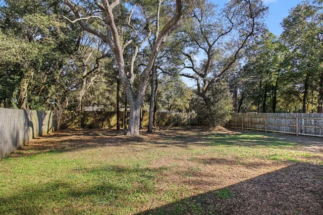 a view of a yard with wooden fence
