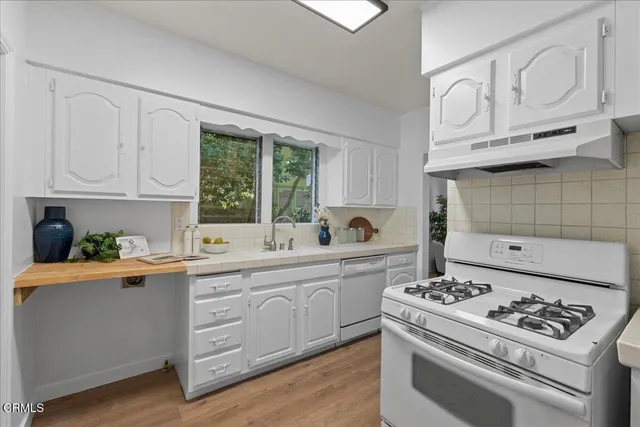a kitchen with appliances cabinets and a large window