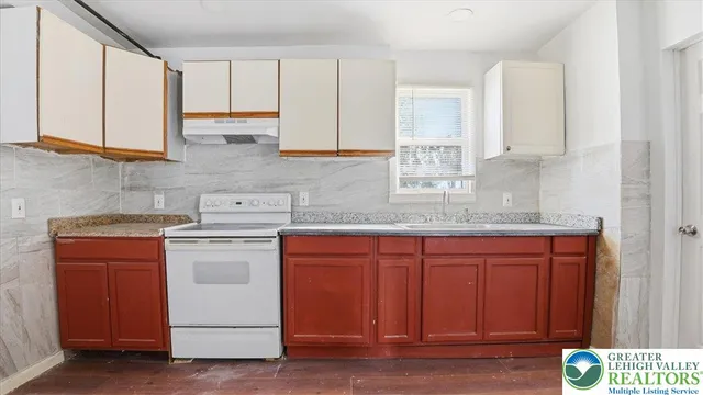a kitchen with stainless steel appliances granite countertop a sink stove and cabinets