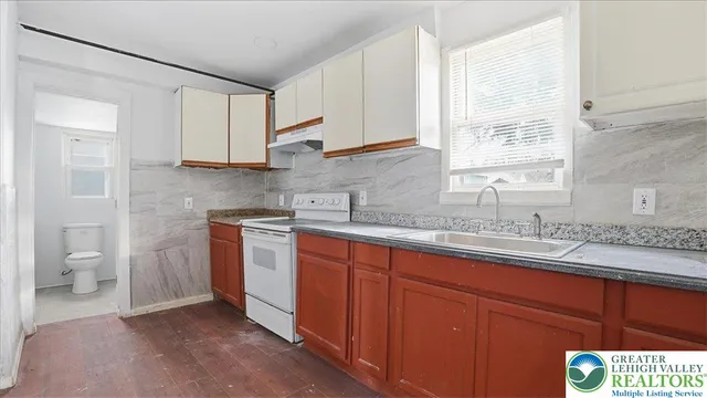 a kitchen with stainless steel appliances granite countertop a sink a stove and a refrigerator