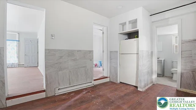 a view of a kitchen with white cabinets and refrigerator