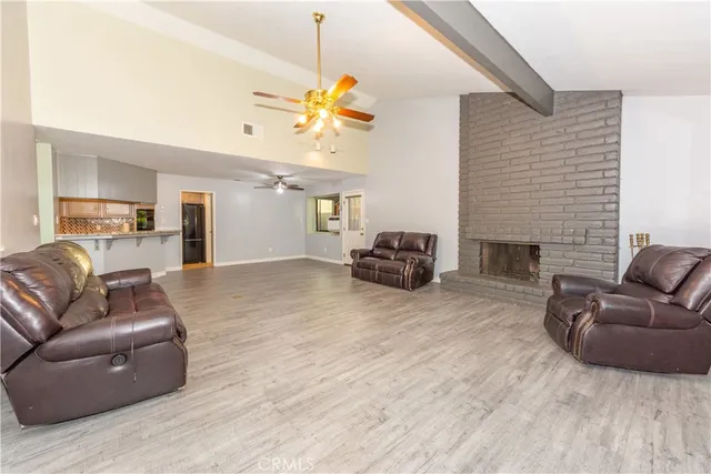 a living room with furniture a fireplace and a ceiling fan