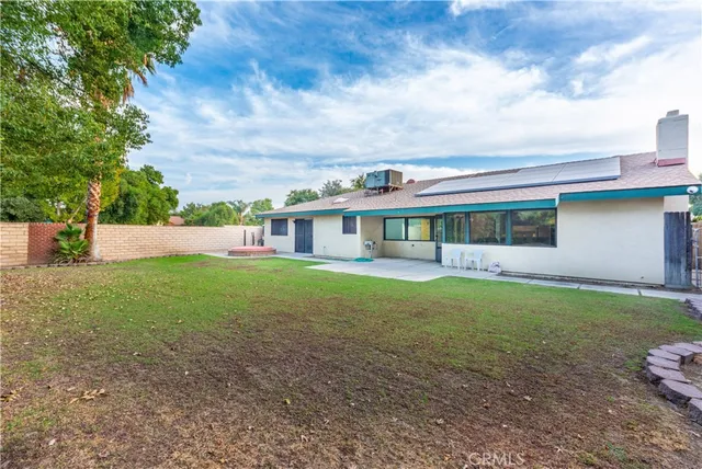 a view of an house with backyard space and balcony