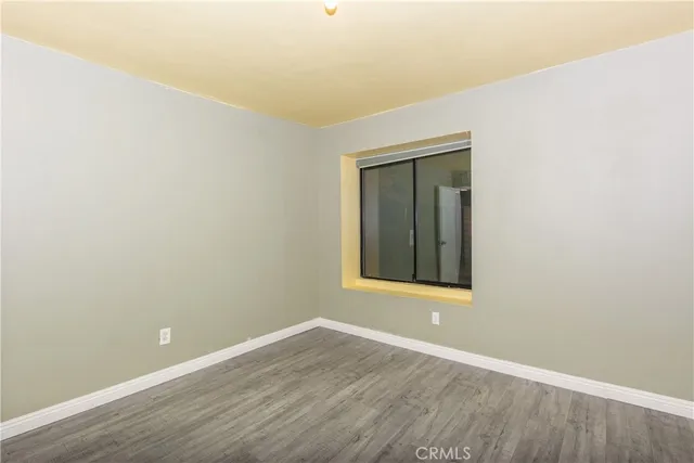 a view of a small space with wooden floor and a window
