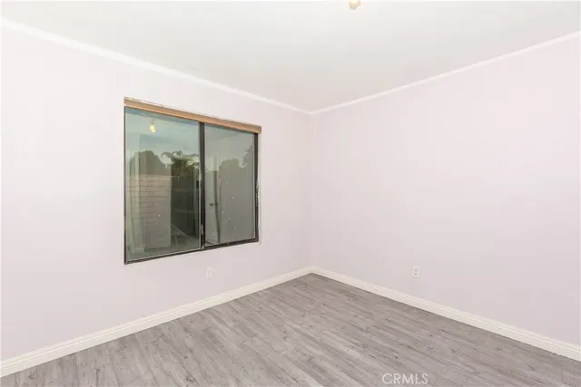 an empty room with wooden floor and mirror