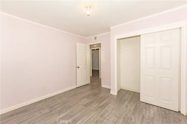 an empty room with wooden floor and closet