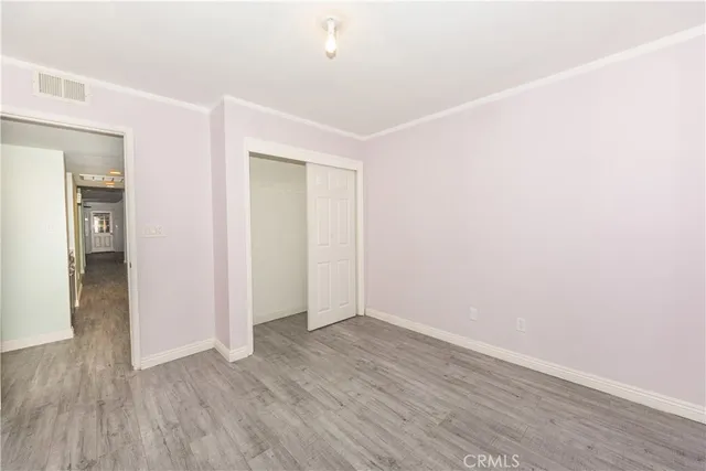 an empty room with wooden floor and closet