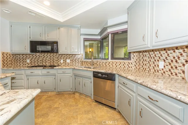 a kitchen with granite countertop cabinets stainless steel appliances a sink and dishwasher