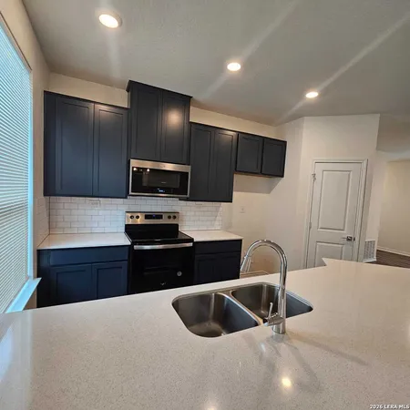 a kitchen with granite countertop a refrigerator stove and microwave