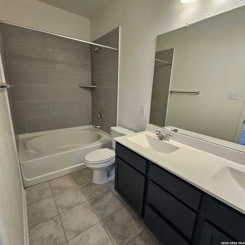a bathroom with a bathtub shower sink vanity and toilet