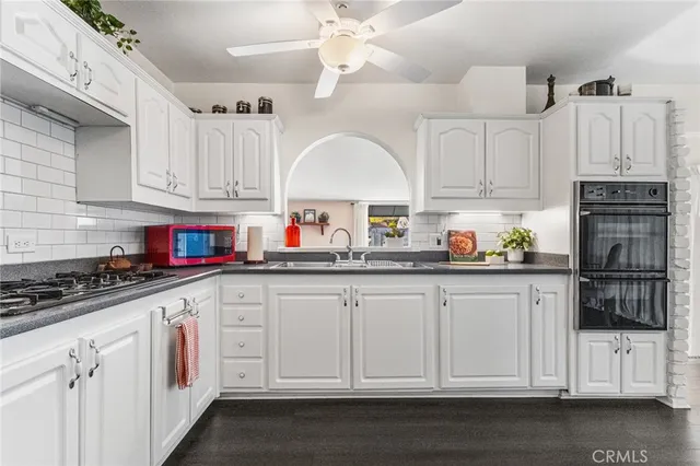 a kitchen with stainless steel appliances granite countertop a stove sink and cabinets