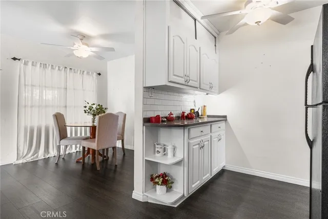 a table with chairs and white cabinets