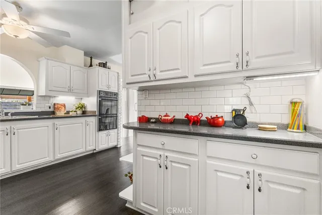 a kitchen with white cabinets and sink