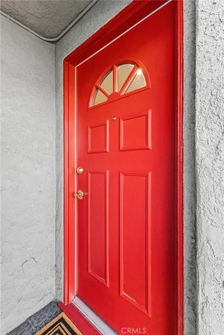 view of empty room with wooden floor and red door