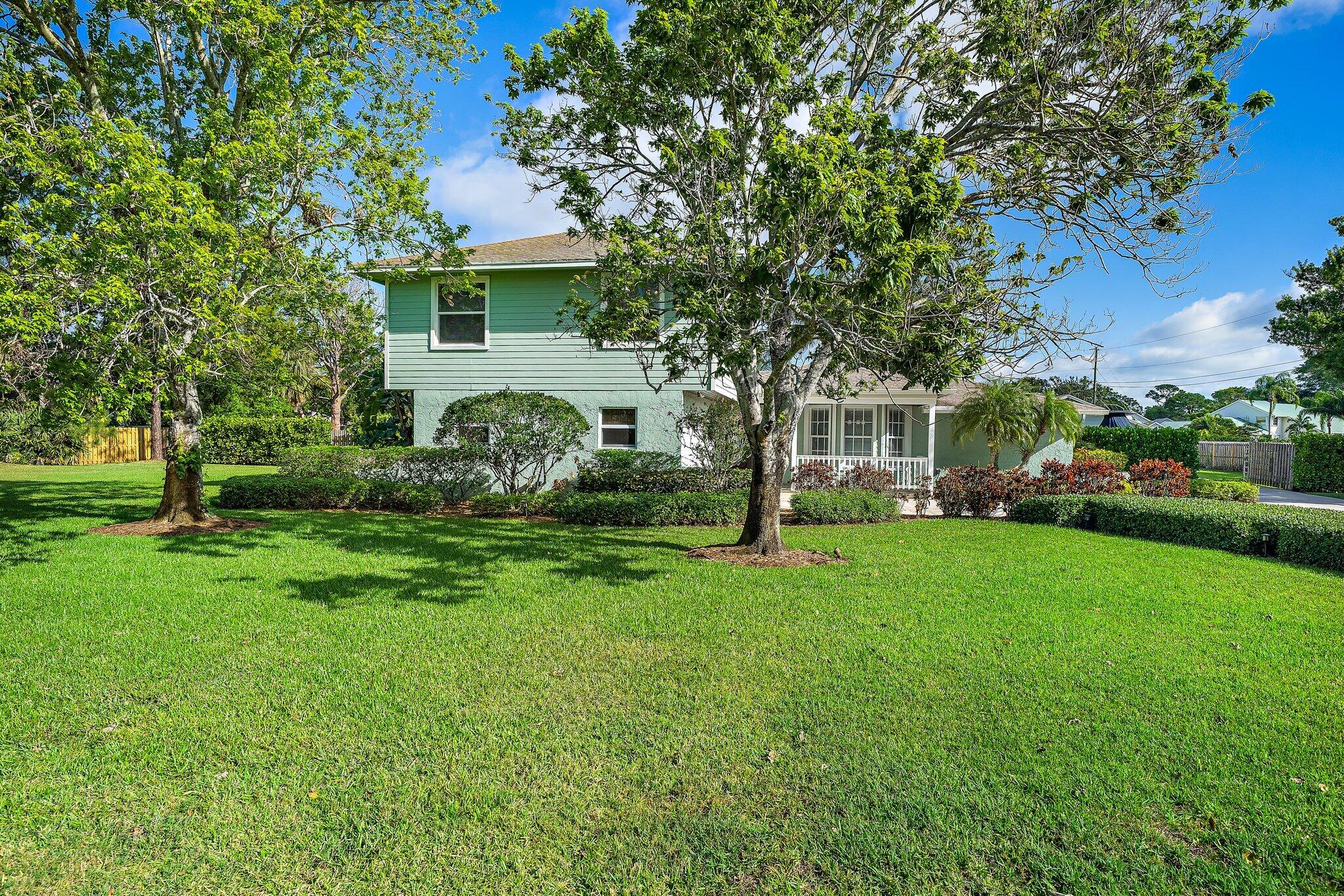 5895 Keith Road Jupiter, FL 33458 - Photo 54 of 62 a view of a house with backyard and a tree