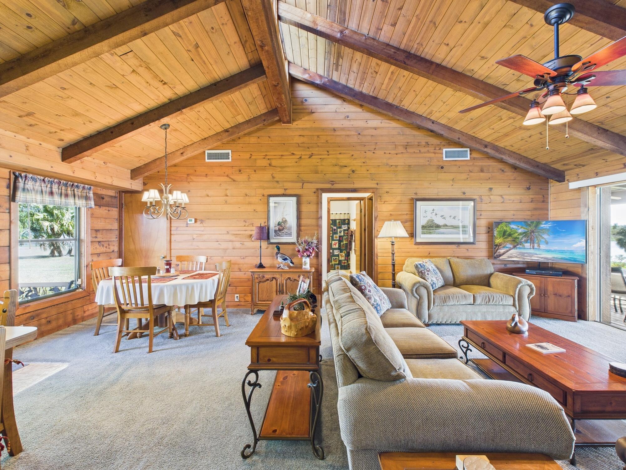 14266 Southwest 144th Parkway Okeechobee, FL 34974 - Photo 13 of 63 a living room with furniture a chandelier and a floor to ceiling window