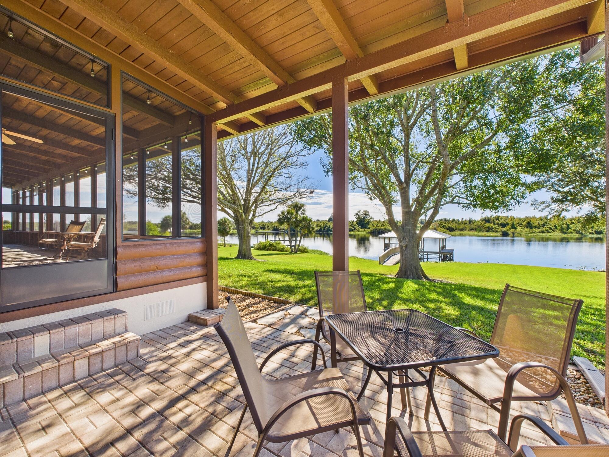 14266 Southwest 144th Parkway Okeechobee, FL 34974 - Photo 49 of 63 a view of a patio with table and chairs under an umbrella