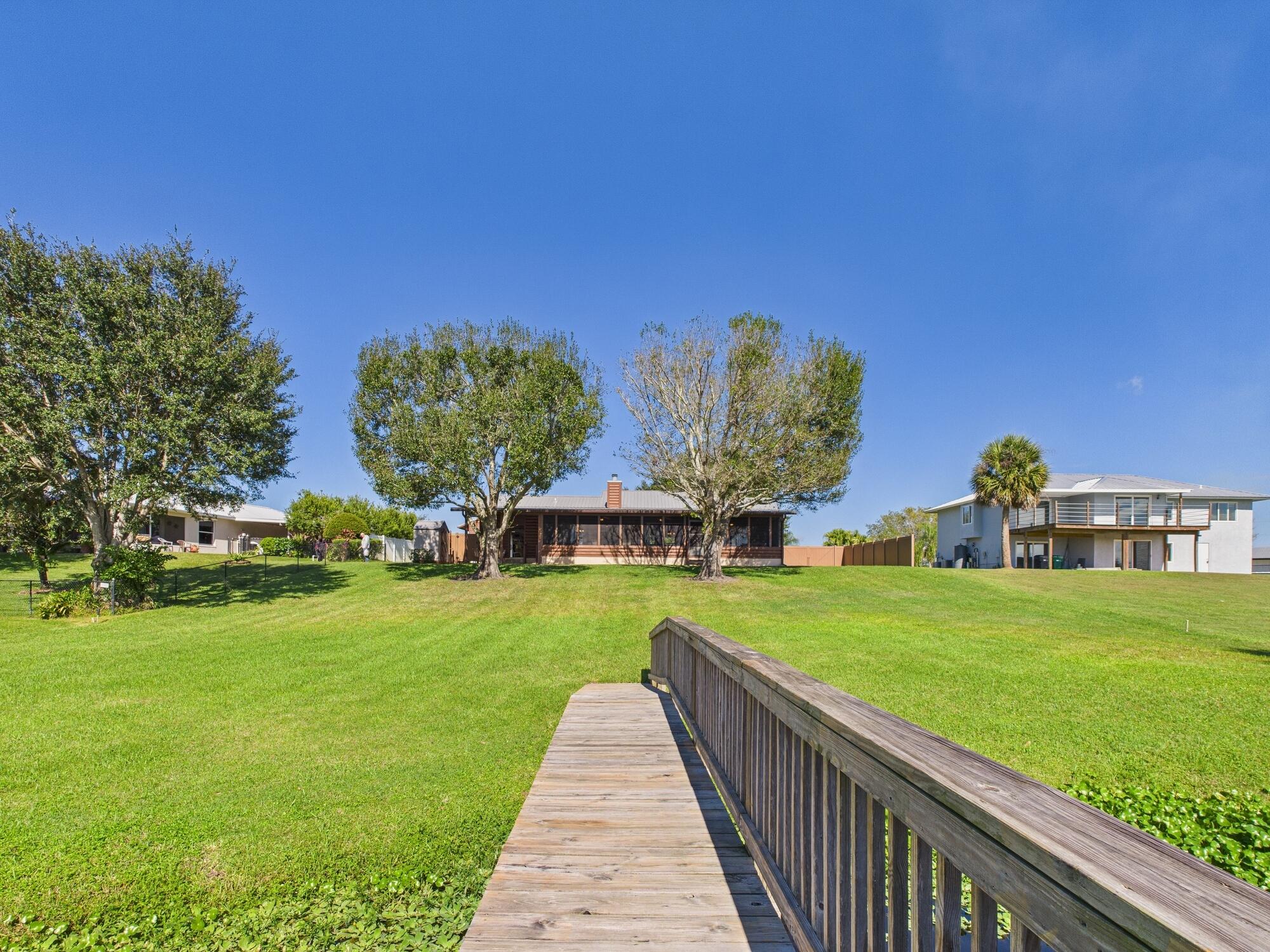 14266 Southwest 144th Parkway Okeechobee, FL 34974 - Photo 58 of 63 a view of a big house with a big yard and potted plants