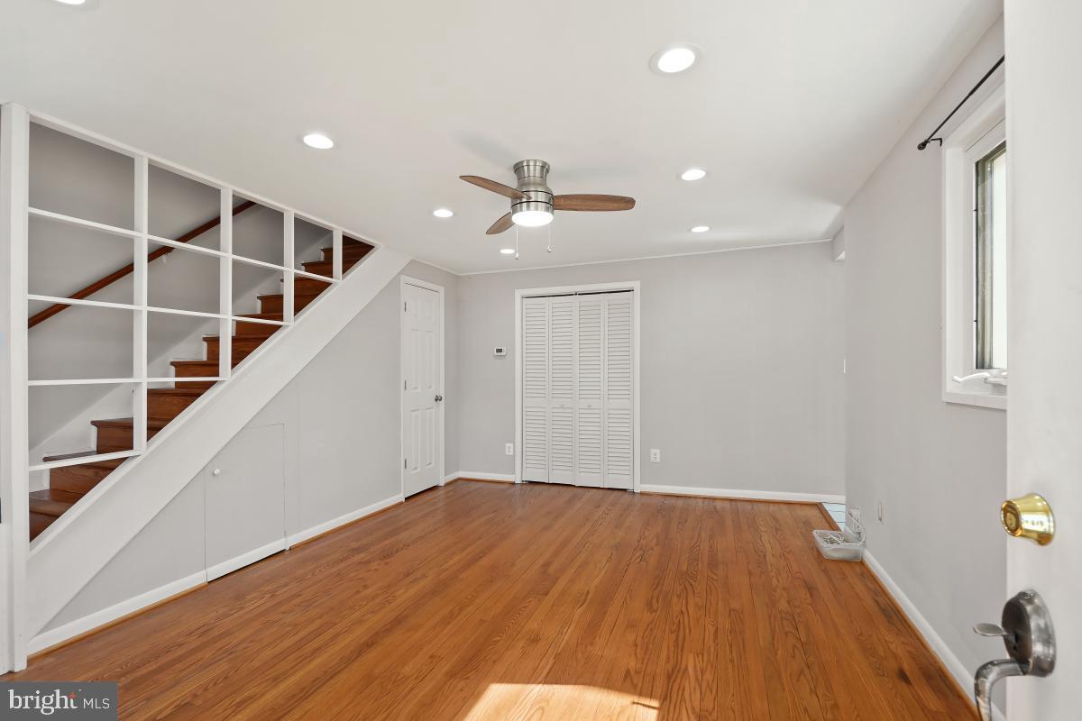 4213 Allison Circle Fairfax, VA 22030 - Photo 4 of 22 a view of an empty room with wooden floor and a ceiling fan
