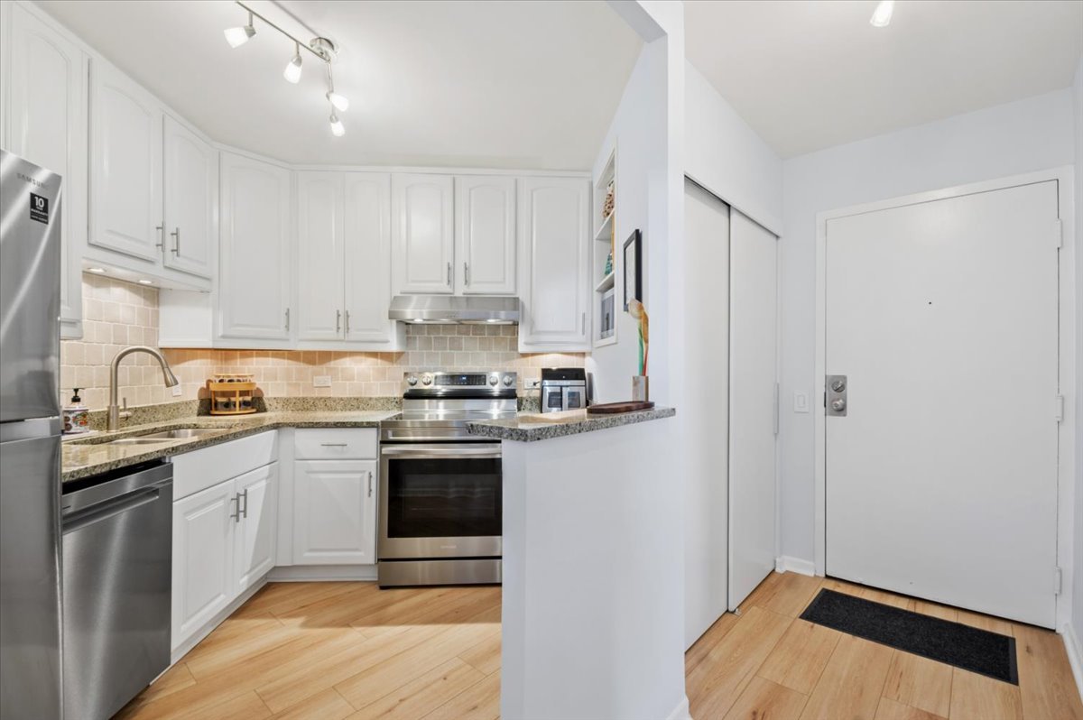 5320 North Sheridan Road, Unit 708 Chicago, IL 60640 - Photo 3 of 19 a kitchen with stainless steel appliances granite countertop a stove a sink and a refrigerator