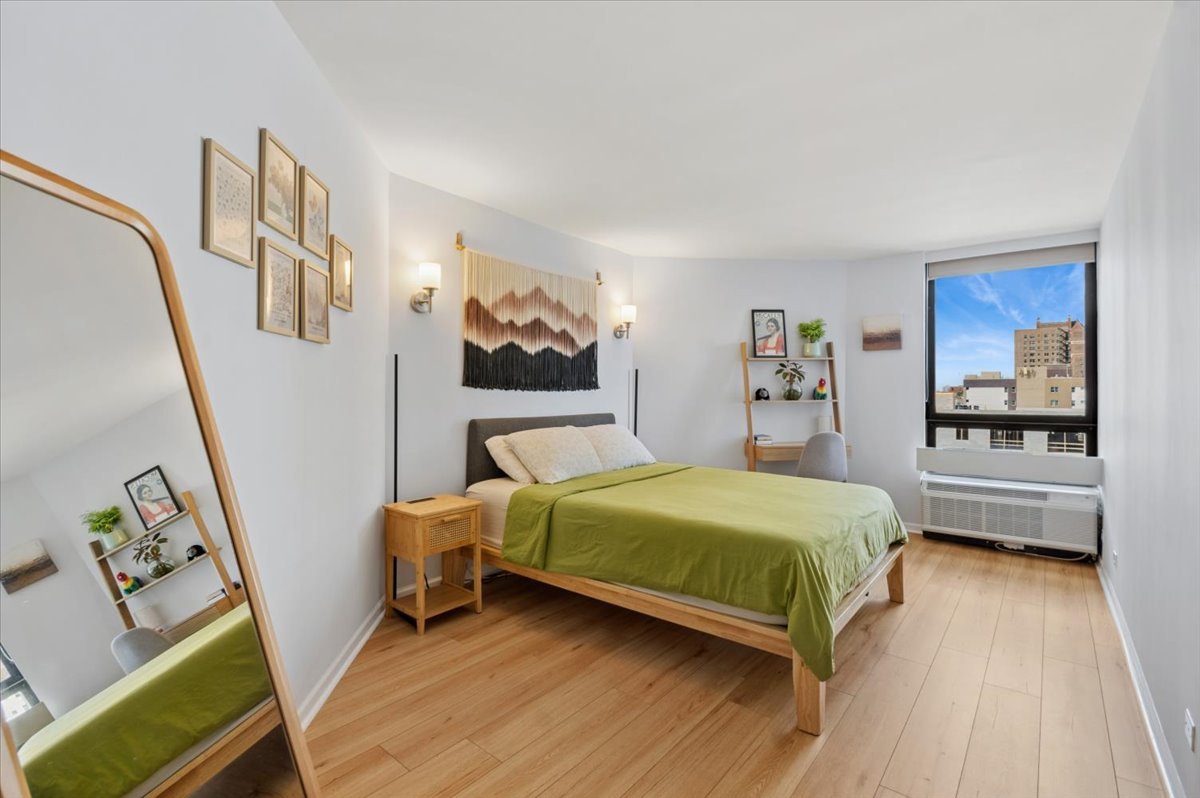 5320 North Sheridan Road, Unit 708 Chicago, IL 60640 - Photo 9 of 19 a bedroom with a bed and a view of living room