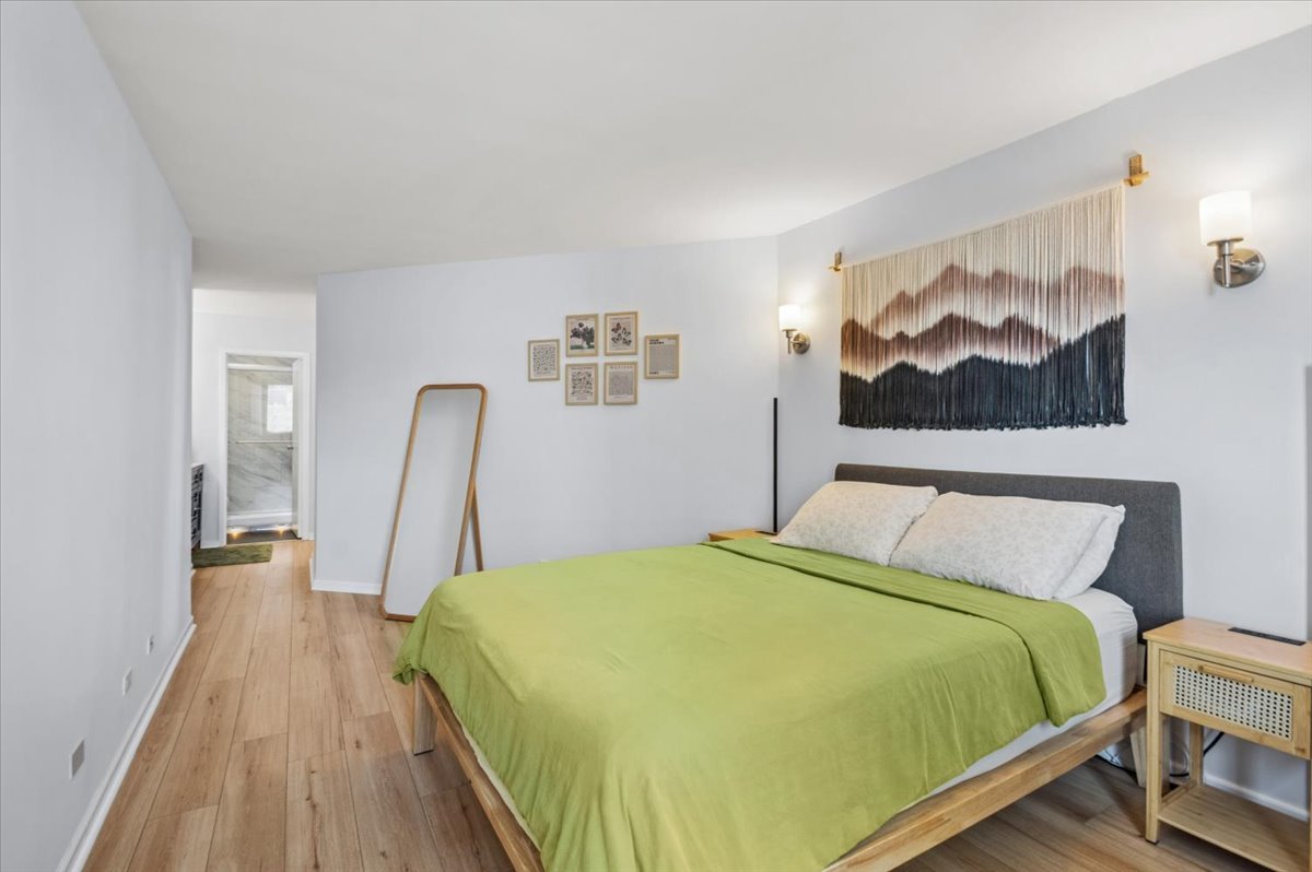 5320 North Sheridan Road, Unit 708 Chicago, IL 60640 - Photo 10 of 19 a bedroom with a bed and a painting on the wall