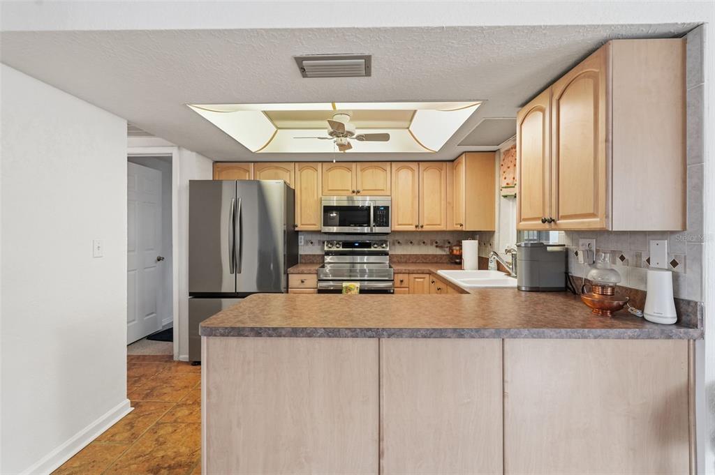 9420 Glen Moor Lane Port Richey, FL 34668 - Photo 13 of 36 a kitchen with stainless steel appliances granite countertop a refrigerator a sink and white cabinets