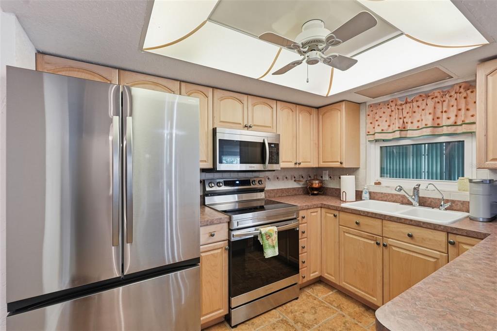 9420 Glen Moor Lane Port Richey, FL 34668 - Photo 14 of 36 a kitchen with stainless steel appliances a stove a sink and a refrigerator