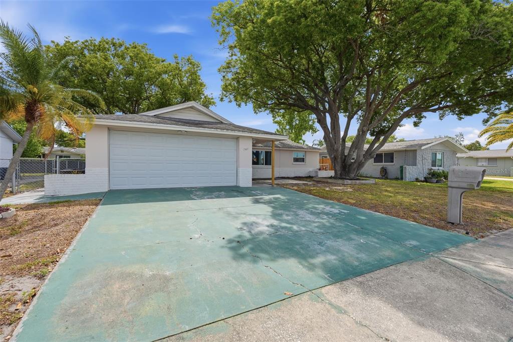 9420 Glen Moor Lane Port Richey, FL 34668 - Photo 2 of 36 a front view of house with yard and trees
