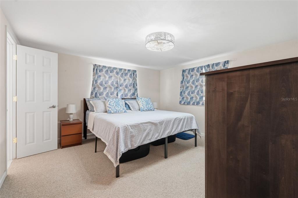 9420 Glen Moor Lane Port Richey, FL 34668 - Photo 21 of 36 a bedroom with a bed and a chandelier