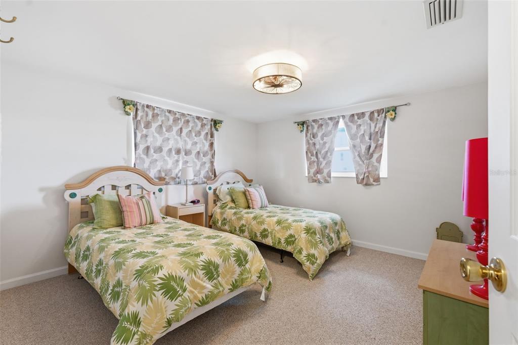 9420 Glen Moor Lane Port Richey, FL 34668 - Photo 27 of 36 a bedroom with two beds and a window