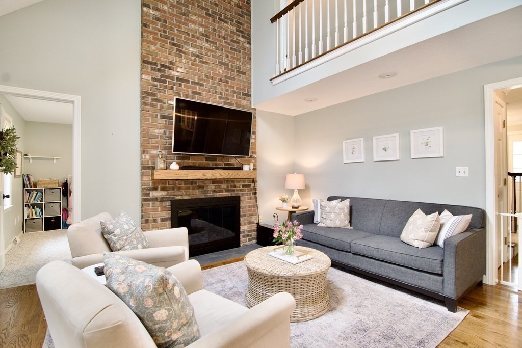 215 Maynard Road Wilbraham, MA 01095 - Photo 17 of 42 a living room with furniture a fireplace and a flat screen tv