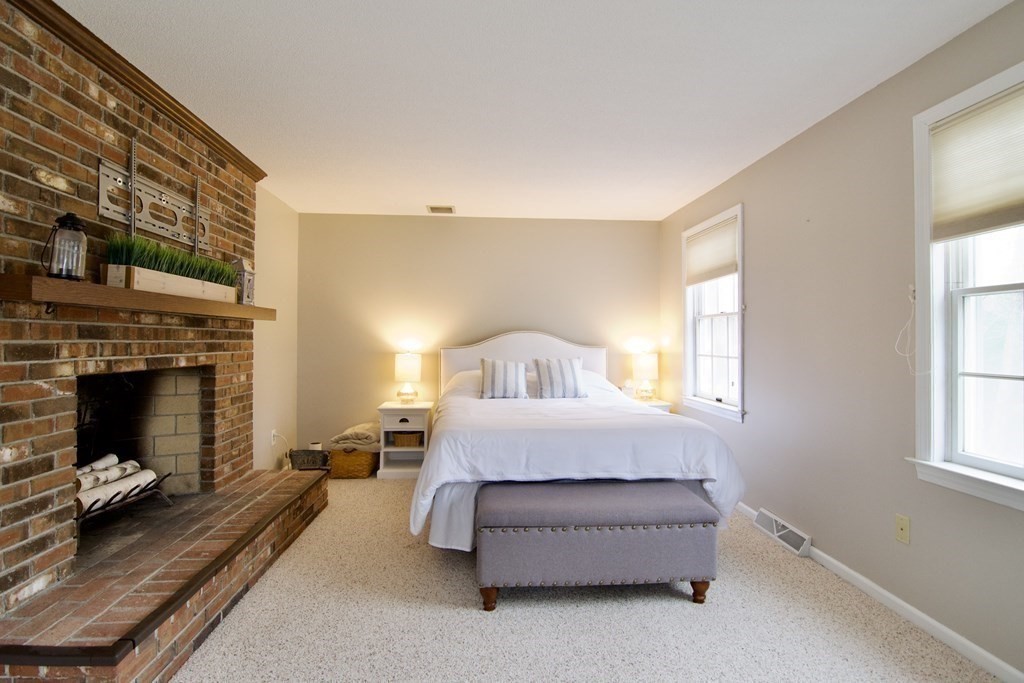 215 Maynard Road Wilbraham, MA 01095 - Photo 24 of 42 a spacious bedroom with a bed and a fireplace