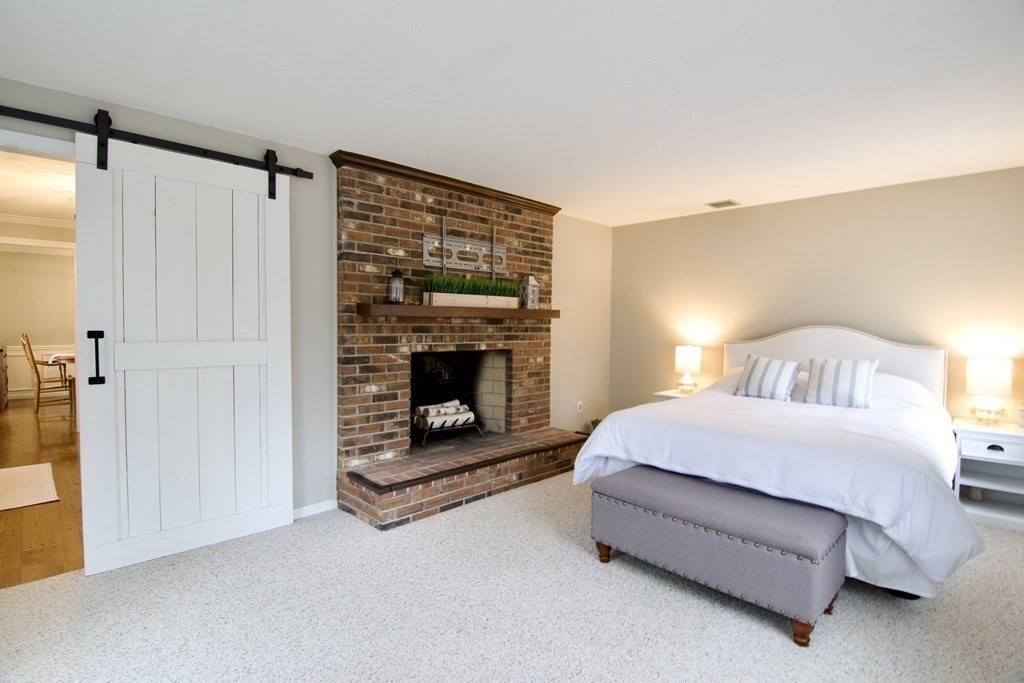 215 Maynard Road Wilbraham, MA 01095 - Photo 26 of 42 a spacious bedroom with a bed and a fireplace