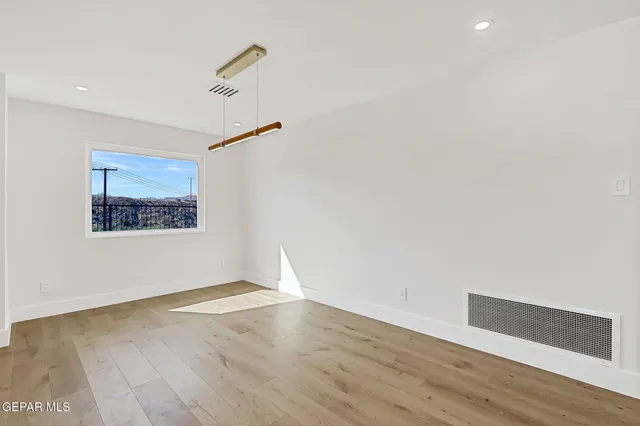 a view of a livingroom with wooden floor and a bathroom
