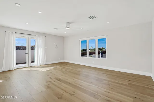 a view of an empty room with wooden floor