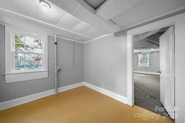 a view of an empty room with window and closet area