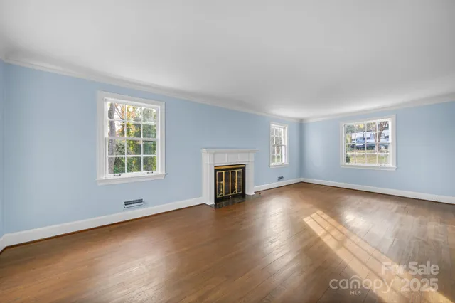 a view of a livingroom with wooden floor and a fireplace