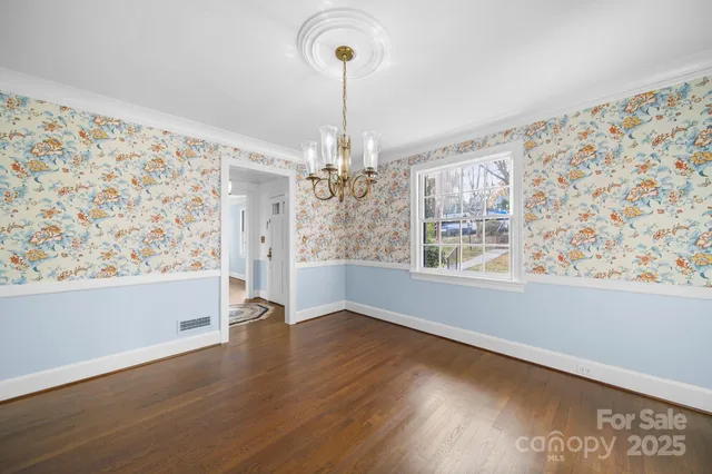 a view of a livingroom with wooden floor and a chandelier