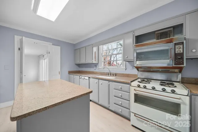 a kitchen with granite countertop a stove cabinets and outdoor view