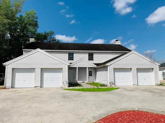 a front view of a house with a garden and garage