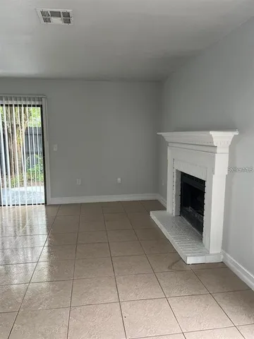 a view of an empty room with a fireplace and a window